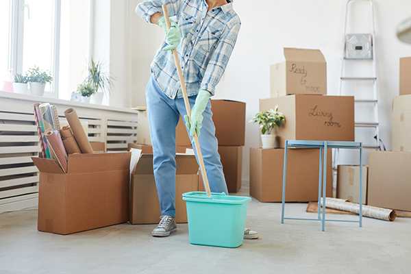 Low section portrait of happy young woman cleaning new house or apartment while moving in, copy space